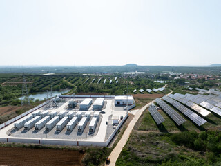 Fototapeta premium Photovoltaic power station with energy storage battery arrays and solar panels in rural area