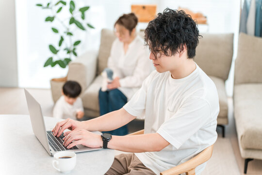 A male businessman working from home using his computer in the living room.