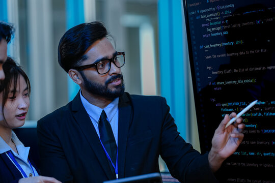 A senior programmer using a stylus to explain intricate machine learning algorithm architecture and Python data structures on a large display panel.