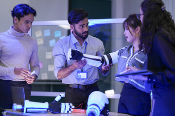 A team of developers testing the articulation parameters of an AI-driven bionic prosthetic arm prototype during a collaborative laboratory project. © ultramansk