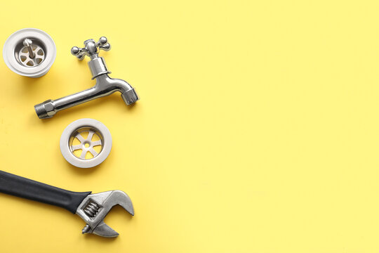 Set of plumber's items on yellow background