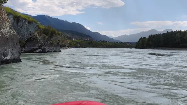A motorboat ride along mountain river. Slow motion of speedboating on Altai river Katun. Mount Camel is in the background.