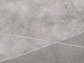 Fototapeta premium Abstract pattern of intersecting white lines on a textured concrete surface