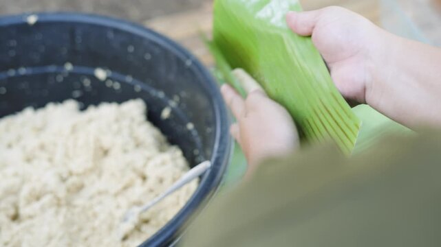 Wrapping Cassava Suman with Coconut Leaves in Traditional Filipino Cooking