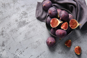 Bowl with fresh ripe figs on grey background