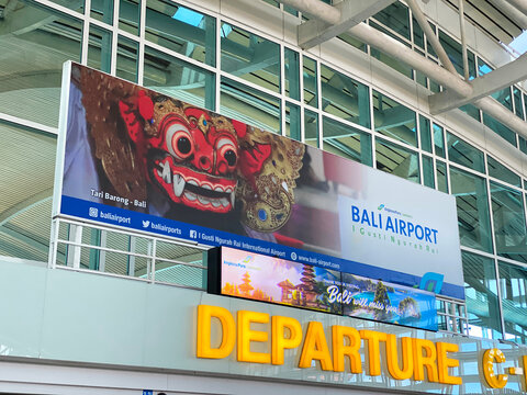 I Gusti Ngurah Rai International Airport departure terminal signage with Barong dance imagery near The Coffee Club and main gate - Bali, Indonesia, April 4, 2023