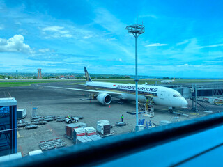 Fototapeta premium Singapore Airlines Boeing 787-10 Dreamliner parked at Gate 6 of Ngurah Rai International Airport for passenger boarding and ground handling - Bali, Indonesia, April 04, 2023