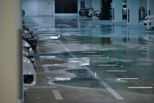 Yilan, Taiwan - Nov 23, 2025: Flooded underground parking, green bay lights on standing water, concrete columns, Jiaoxi Township, Yilan County, flood risk.