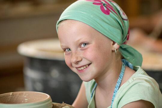 Leukemia girl cancer kid smiling headscarf pottery studio