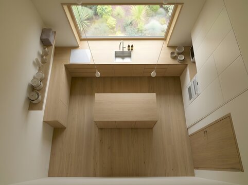 Modern wooden kitchen with a large skylight offering a view of a lush garden