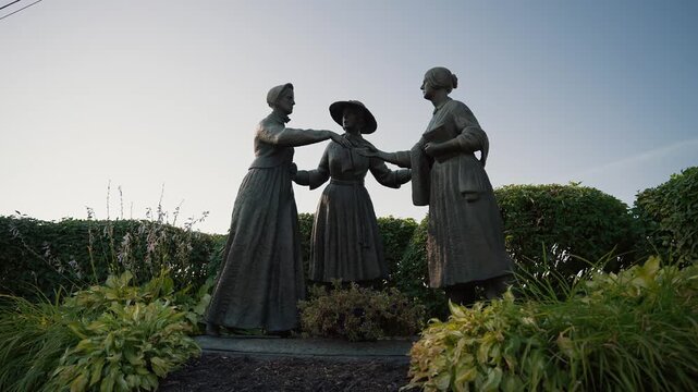 Bronze suffragist statues at Women's Rights National Park at dusk in Seneca Falls, NY "Anthony-Stanton-Bloomer Statue."