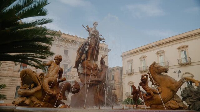 Wide establishing shot of the historic Piazza Archimede with its iconic fountain in Ortygia Syracuse Sicily