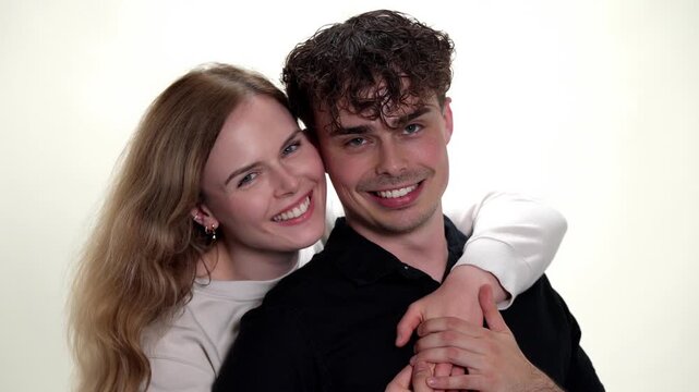 A young couple displays affection and romance as the woman gently kisses the man s cheek, highlighting concepts of love, happiness, and togetherness. This intimate moment captures their genuine connec