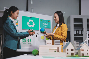 Naklejka premium Two business people team planning and discussing of sustainable and renewable clean energy product with solar cell and wind turbine generator, CO2 emissions climate change global warming project