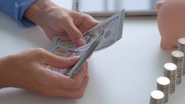 Asian businessman counting banknote with stacking coin and piggy bank on table investment concept.