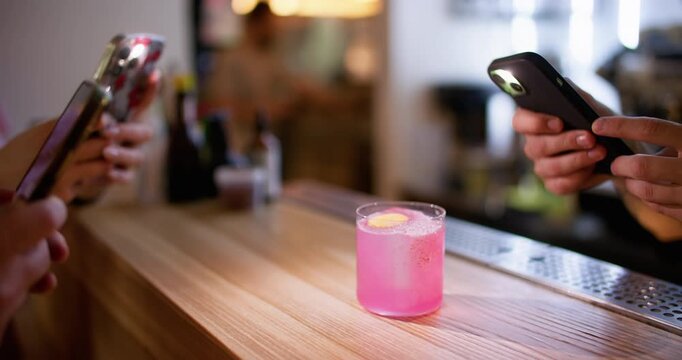Cocktail taking photo. Bright drink. Customer hands making pictures content with smartphones capture flash refreshing beverage in pub.