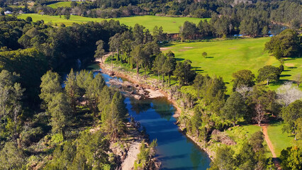 Fototapeta premium Aerial View of a Winding River Through Lush Green Valley in Australia