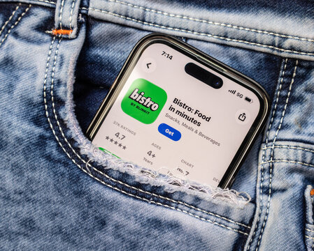 Smartphone displaying bistro app store page in a jeans pocket closeup