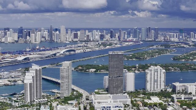 Aerial skyline of Miami Beach, Florida at sunset with bay, highrise buildings and dramatic clouds. g.