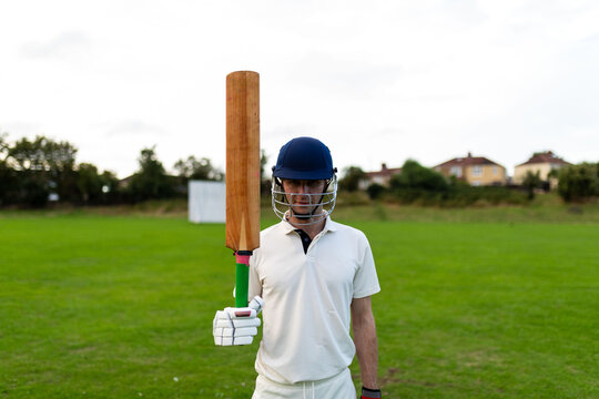 Cricket player holding bat outdoors
