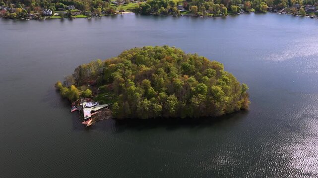 Aerial view of the Massaro House on Petre Island upstate. A unique triangular house on private island in Mahopac Lake surrounded by trees. The camera tilted downward zoom in towards the little island.