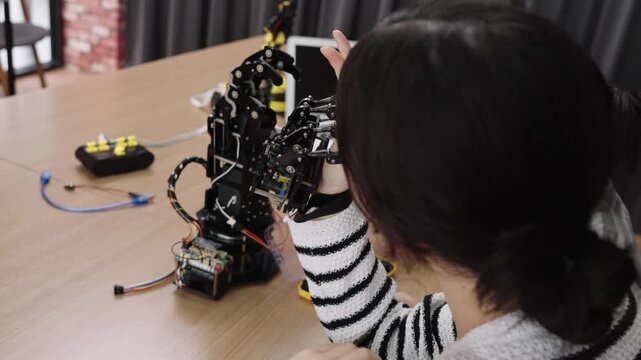 Students learning STEM robotics by assembling and testing robotic arms in classroom experiments.