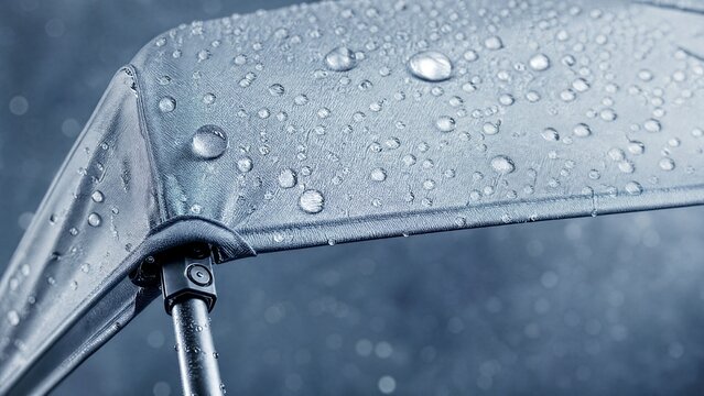 Waterproof canopy with shimmering droplets, showcasing innovative rain protection in sleek silver-blue hues.