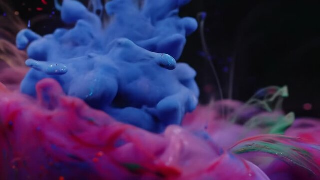 Extreme macro video of luminous golden, ruby, fuchsia, sapphire, emerald ink blooming, blending against black. Soft cinematic light, fluid dynamics abstract art