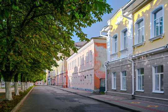 Green alley with old buildings on Lenin Street in Livny, Oryol region of Russia