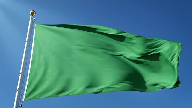 Green flag waving in blue sky for creative digital media and visual arts