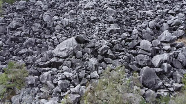 Gloppedalsura boulder field, a massive rock scree from an ancient landslide in Norway, revealing a desolate and rugged mountain landscape with sparse vegetation