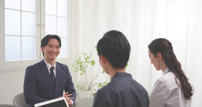 クリニックの会議室で打ち合わせをする若い医師とビジネスマン