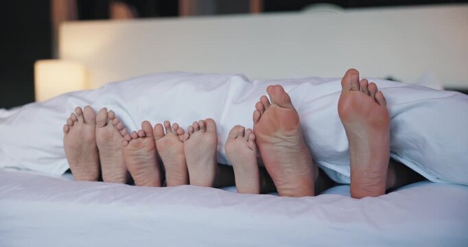 Feet, parents and children with blanket in bedroom for rest, family sleeping and calm morning. Toes, people and kids with duvet for weekend nap, comfortable and lying barefoot on cozy bedding in home