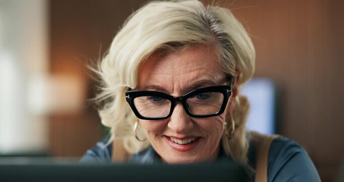 Laptop, glasses and businesswoman in office with research for finance report with stock market. Happy, professional and mature financial manager with computer for investment proposal in workplace.