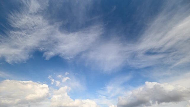 Sky shows rapid layered cloud movement. High and low clouds flow with changing light and color. Panoramic aerial view captures dynamic cloud movements across expansive sky