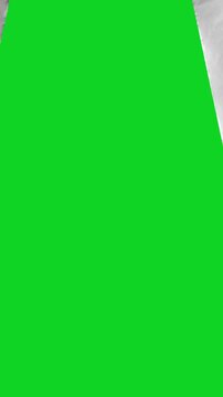 Vertical torn crumpled white grunge paper split revealing animated on a green screen chroma key background. It gives a high quality professional template design element for video compositing