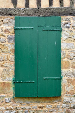 Green Painted Window Shutters on Medieval Stone Wall in French Village