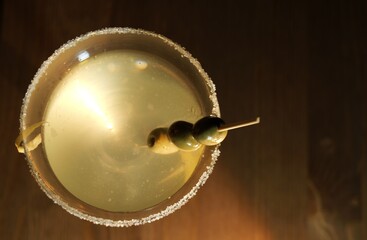 Obraz premium Martini cocktail with olives and salted rim on dark background