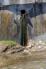 Fototapeta premium Leaking pipe releases water into muddy ground