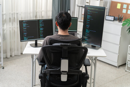 Modern Software Developer Working at Multi-Monitor Desk in Bright Office