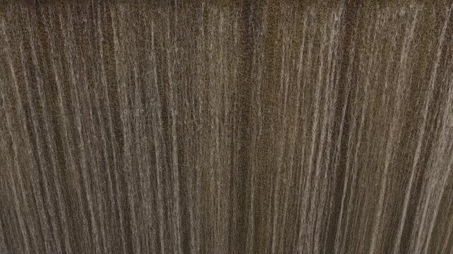 Detailed view of vertical streaks of falling water creating textured pattern at waterfall