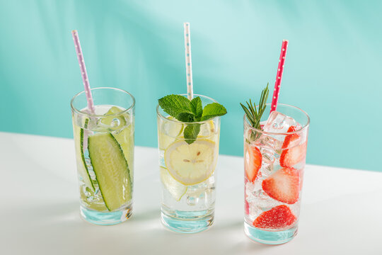 Set of fresh non alcoholic drinks with strawberry cucumber and lemon on blue background