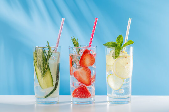 Set of fresh non alcoholic drinks with strawberry cucumber and lemon on blue background