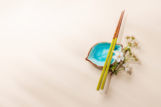 Minimal asian composition with chopsticks and blossom branch