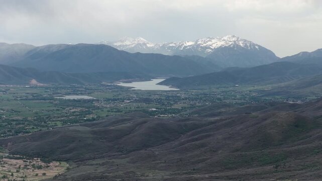 High aerial of Wasatch Range and Deer Creek Reservoir in spring with stormy sky in Utah