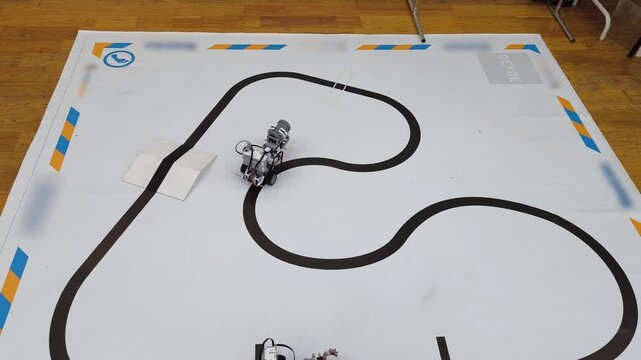 Top view - the robot passes a marked track with an obstacle on the training field for competitions in robotics, STEM, programming.
