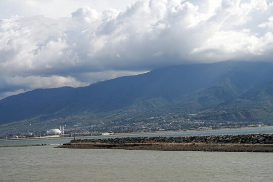 Distant mountains loom under heavy, drifting clouds