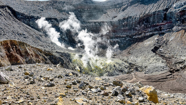 A volcano crater with an acid lake (explosion lake) and steaming fumaroles (solfatare) and hot springs. Sulawesi. Indonesia