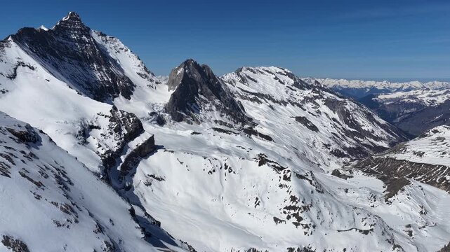 Sunny drone view of Tignes and Grande Motte glacier surrounded by snowy mountains in the French Alps during spring. Drone view of alpine glacier and snowy mountain peaks in French Alps
