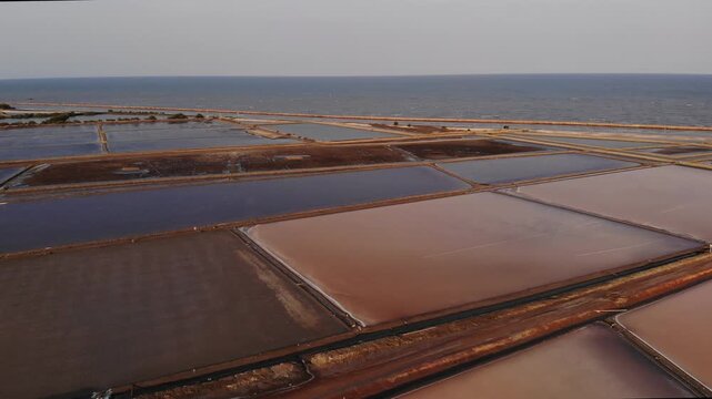 Aerial view of salt harvesting ponds over coastal Thailand, crystal salt ponds.